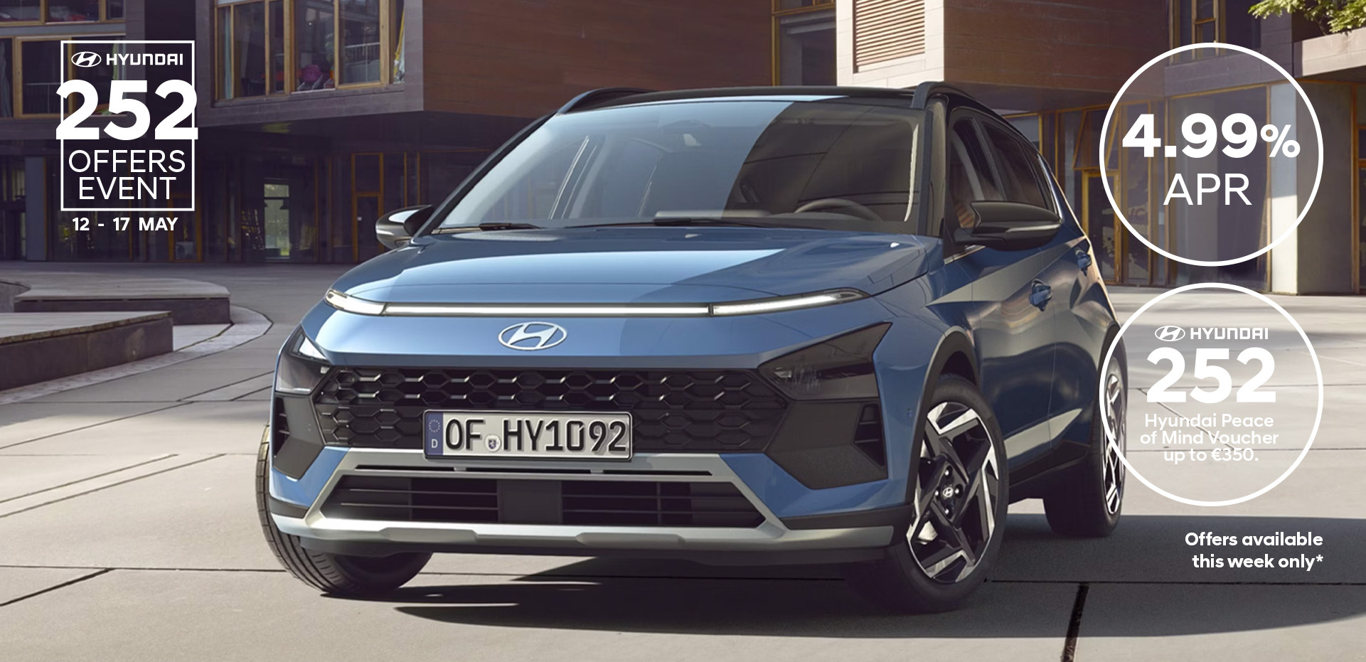 The new Hyundai BAYON is seen the front, with urban housing in the background.
