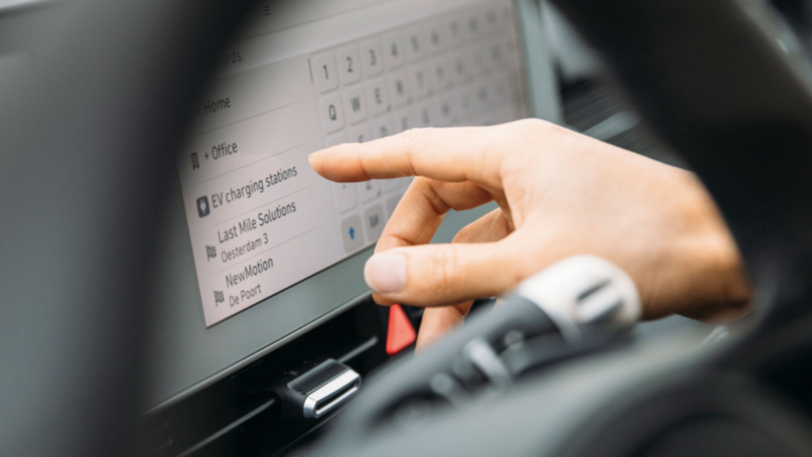 A driver of a Hyundai electric vehicle looking for a charging station on the display.