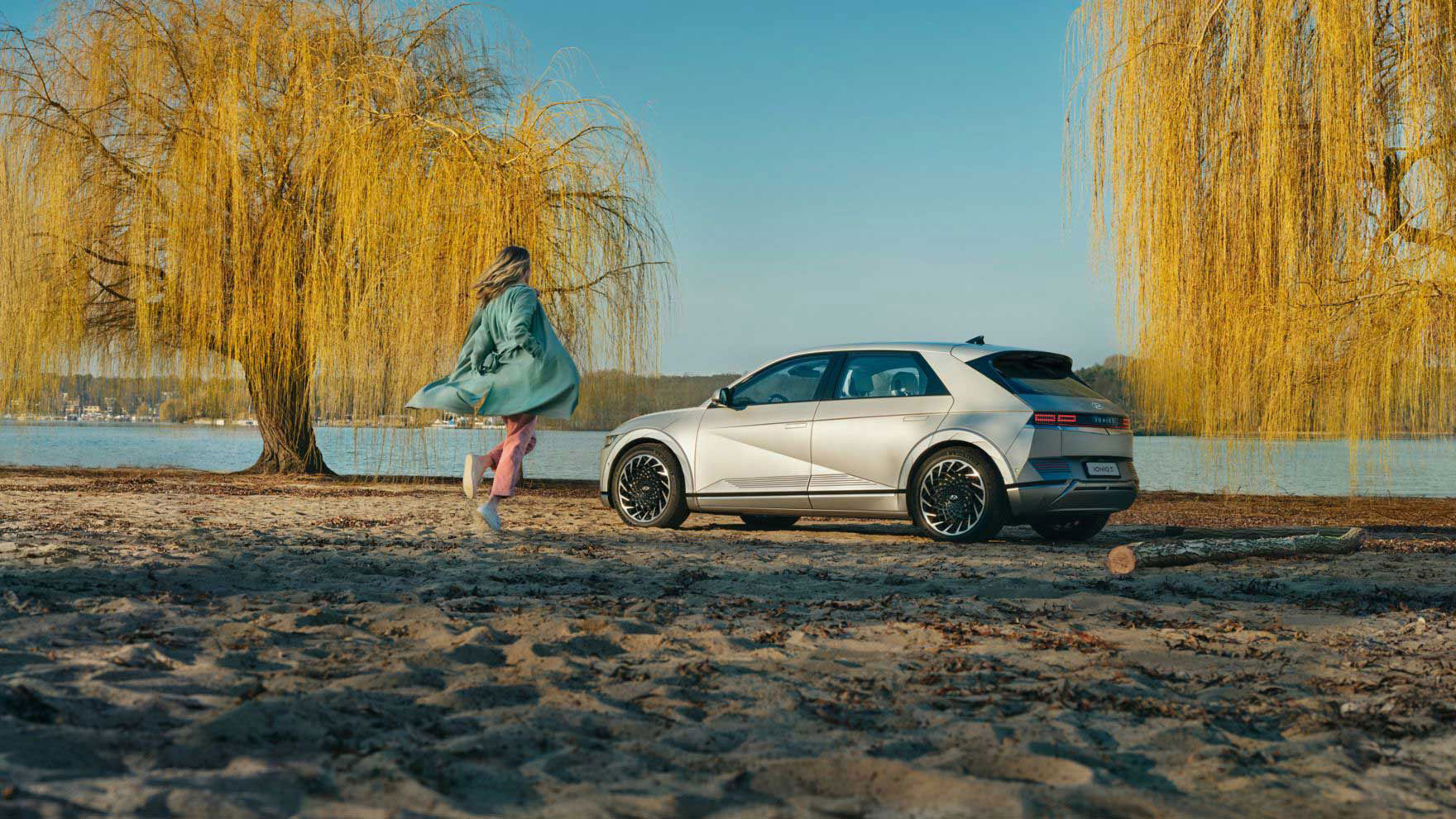 A person on a beach, approaching their Hyundai IONIQ 5 electric midsize CUV.