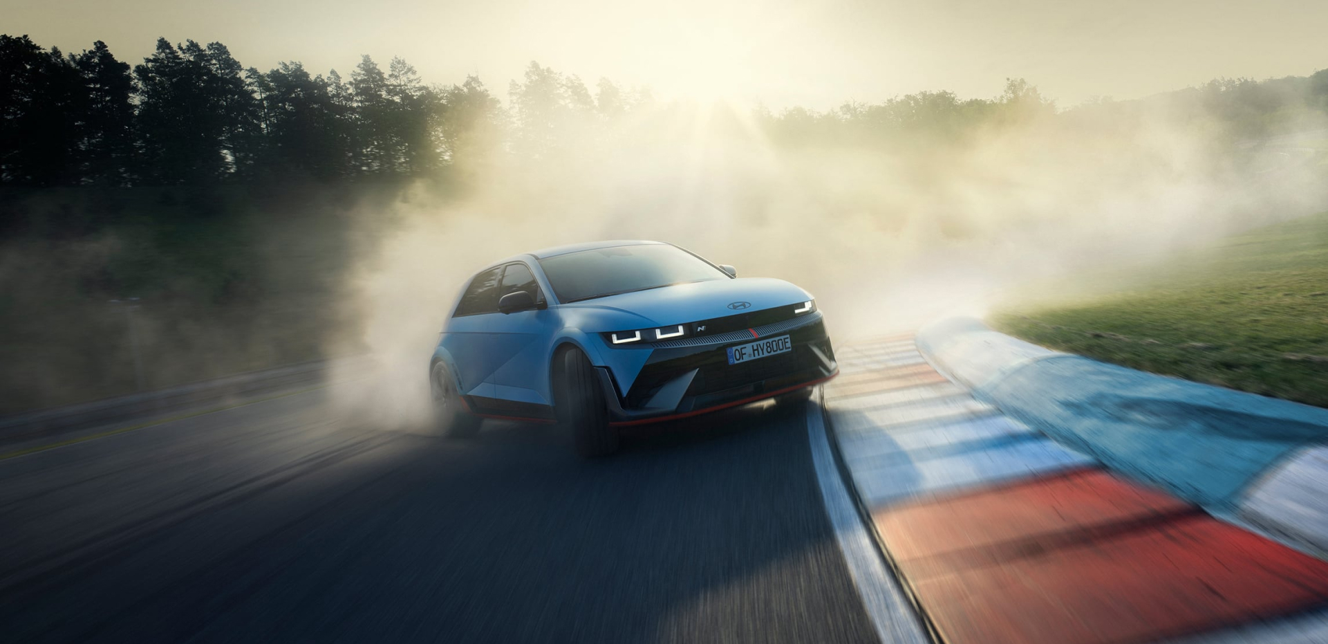 The all-electric Hyundai IONIQ 5 N drifting through a curve on a racetrack with smoking tyres.