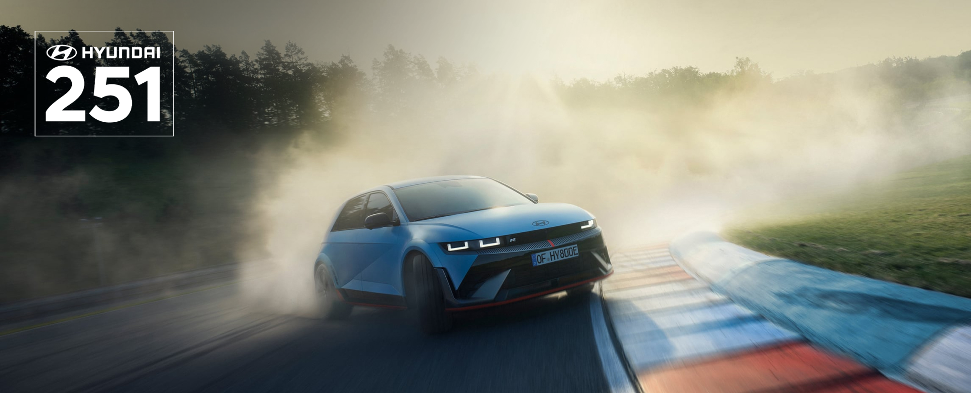 The all-electric Hyundai IONIQ 5 N drifting through a curve on a racetrack with smoking tyres.