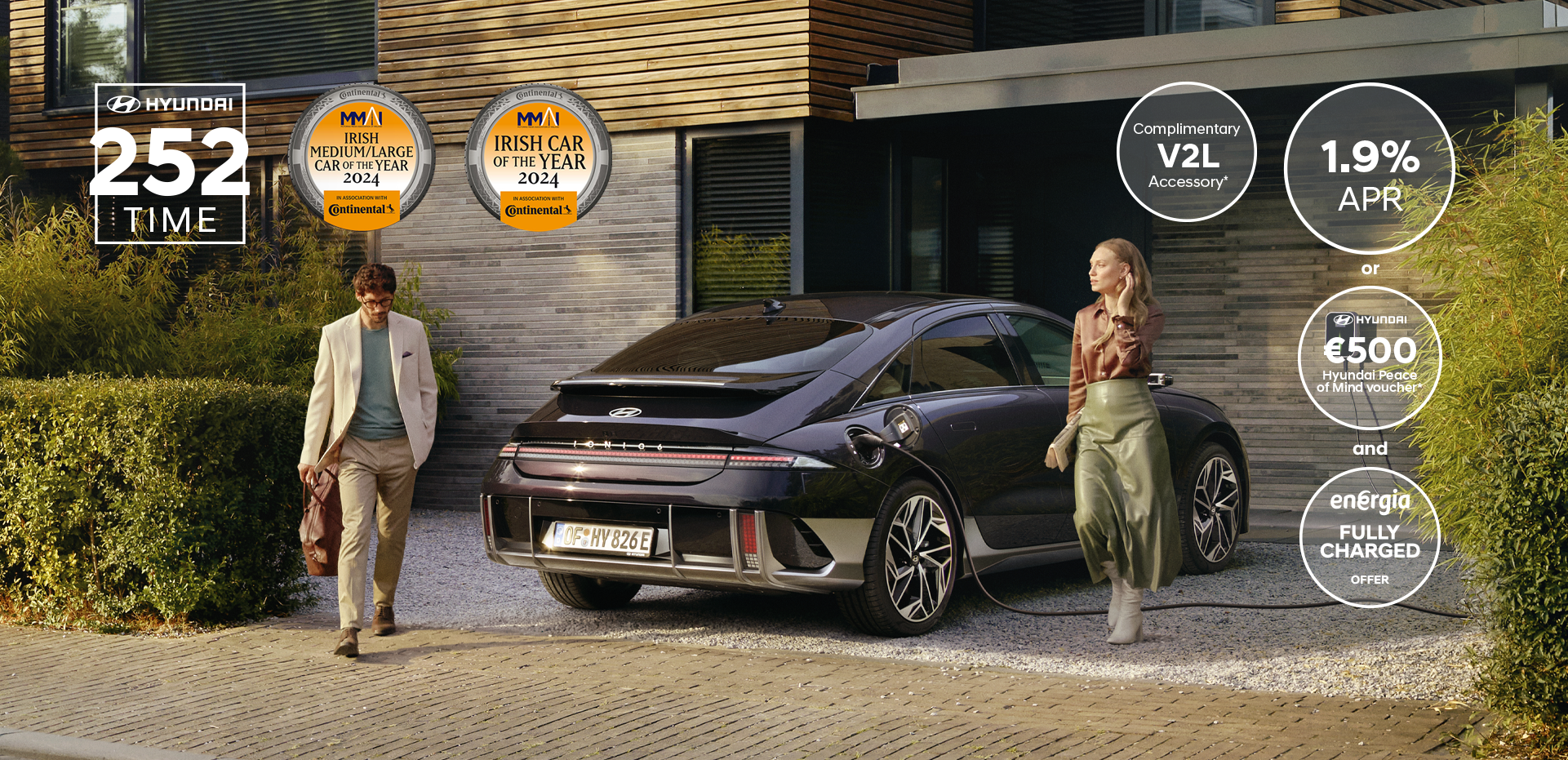 The all-electric Hyundai IONIQ 6 charging in a city with a man leaning on it with an ice cream.