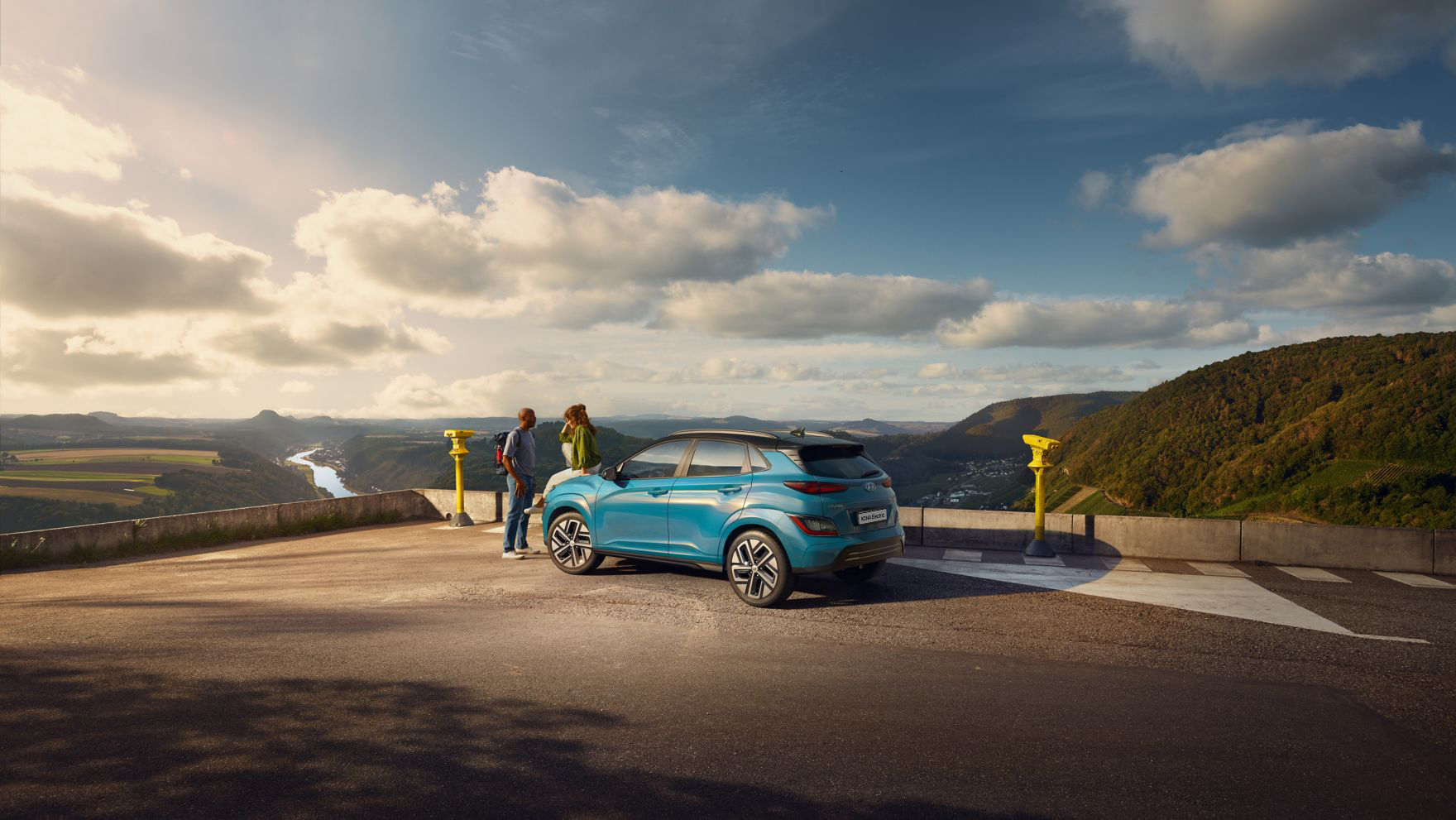 The new Hyundai Kona Electric in Dive in Jeju from the side standing in a parking lot.