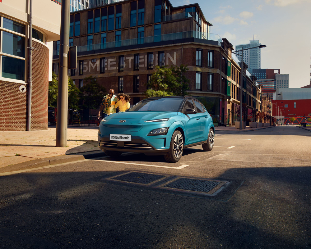 The new Hyundai Kona Electric from the front in Dive in Jeju, standing on a road in the city.