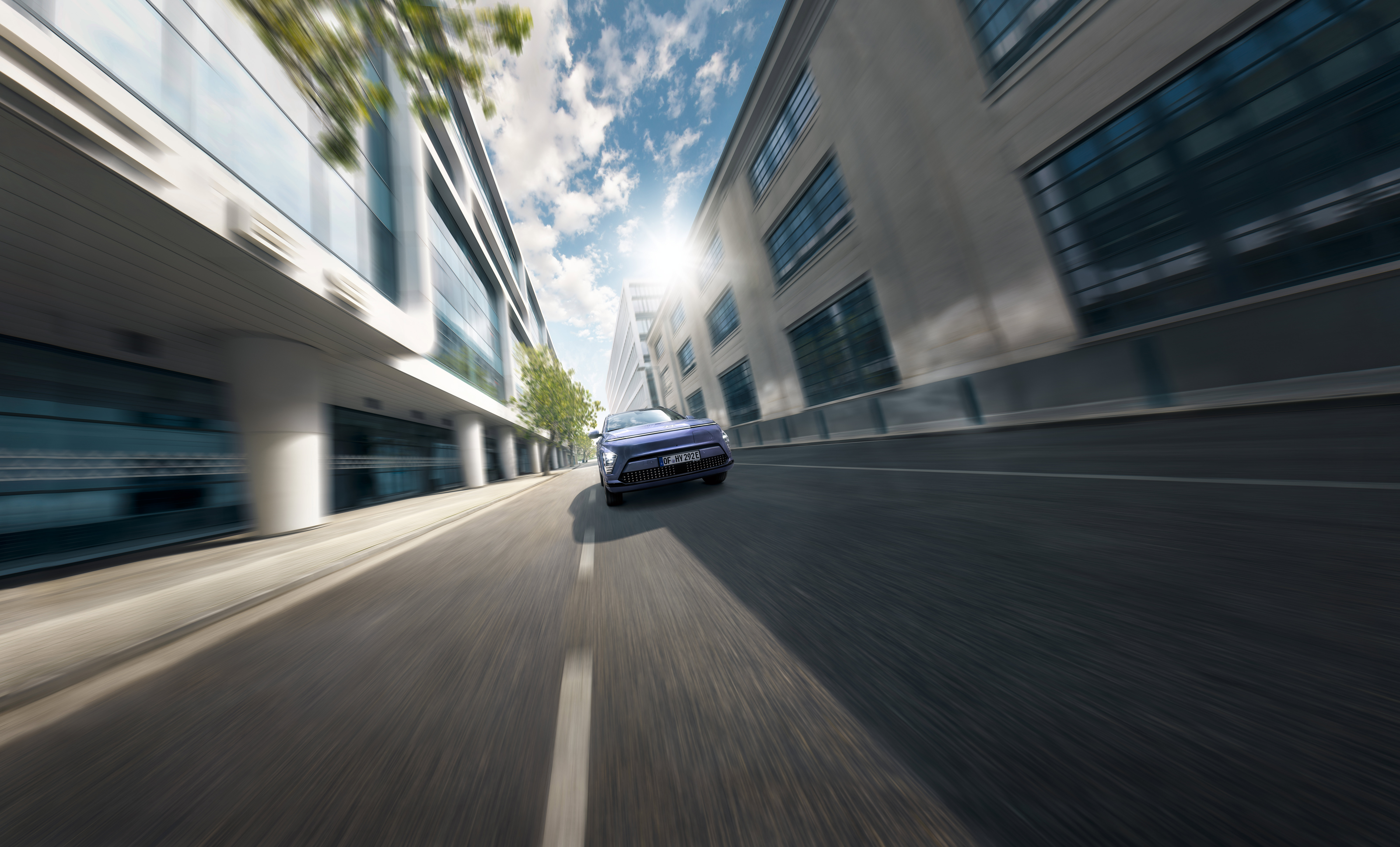 The Hyundai KONA Electric pictured from the side driving over a bridge. 