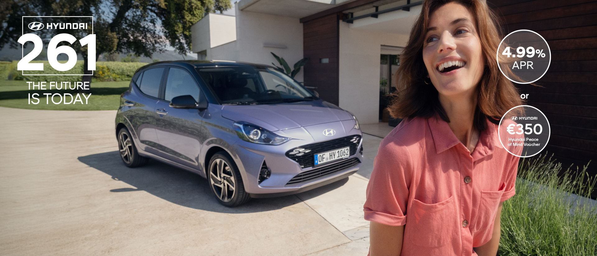 A woman walking and smiling in front of the new Hyundai i10.