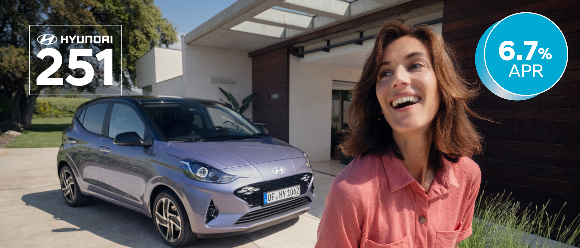 A woman walking and smiling in front of the new Hyundai i10.