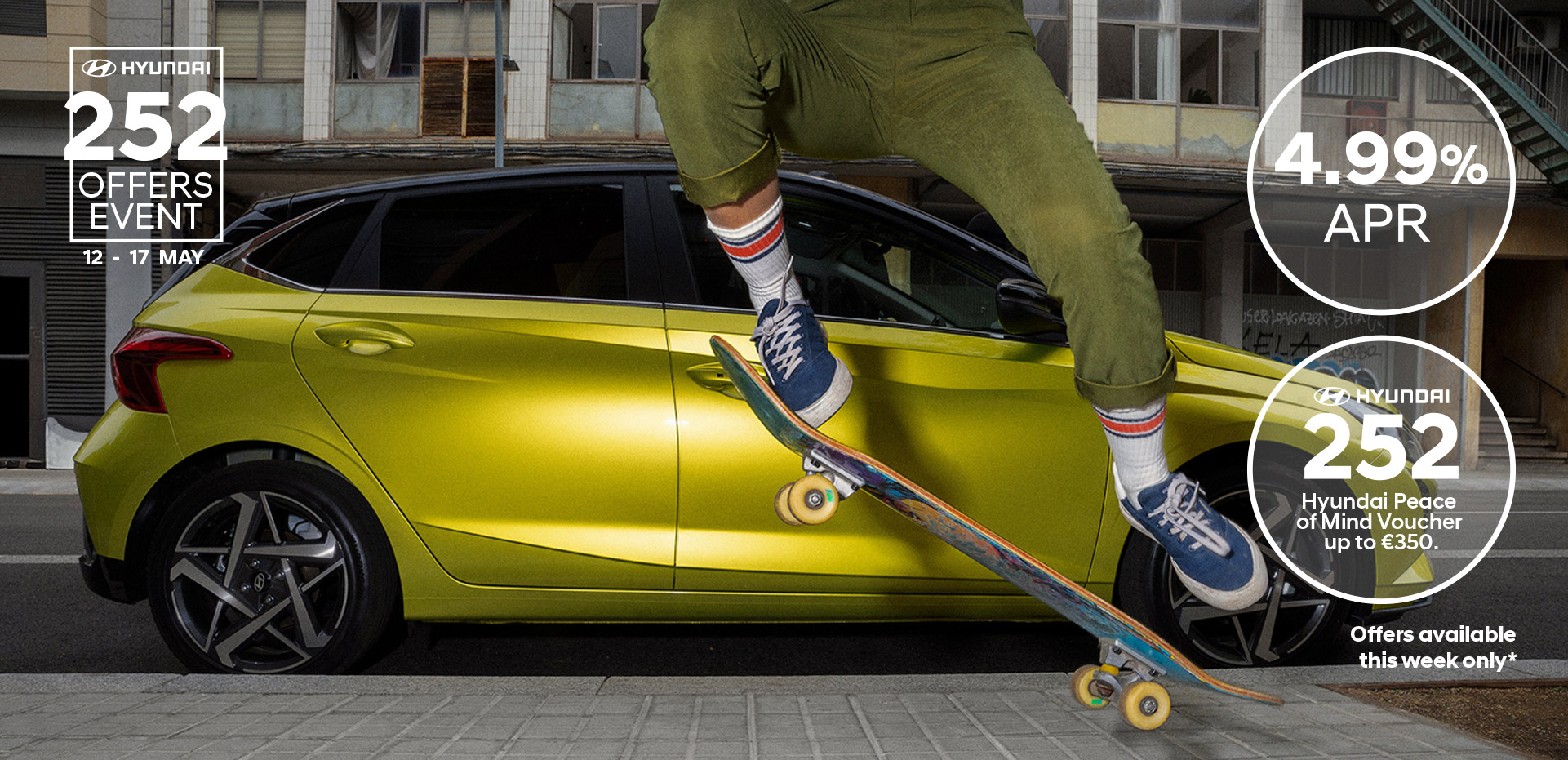A young woman skateboarding in the street with a Hyundai i20 in the background.