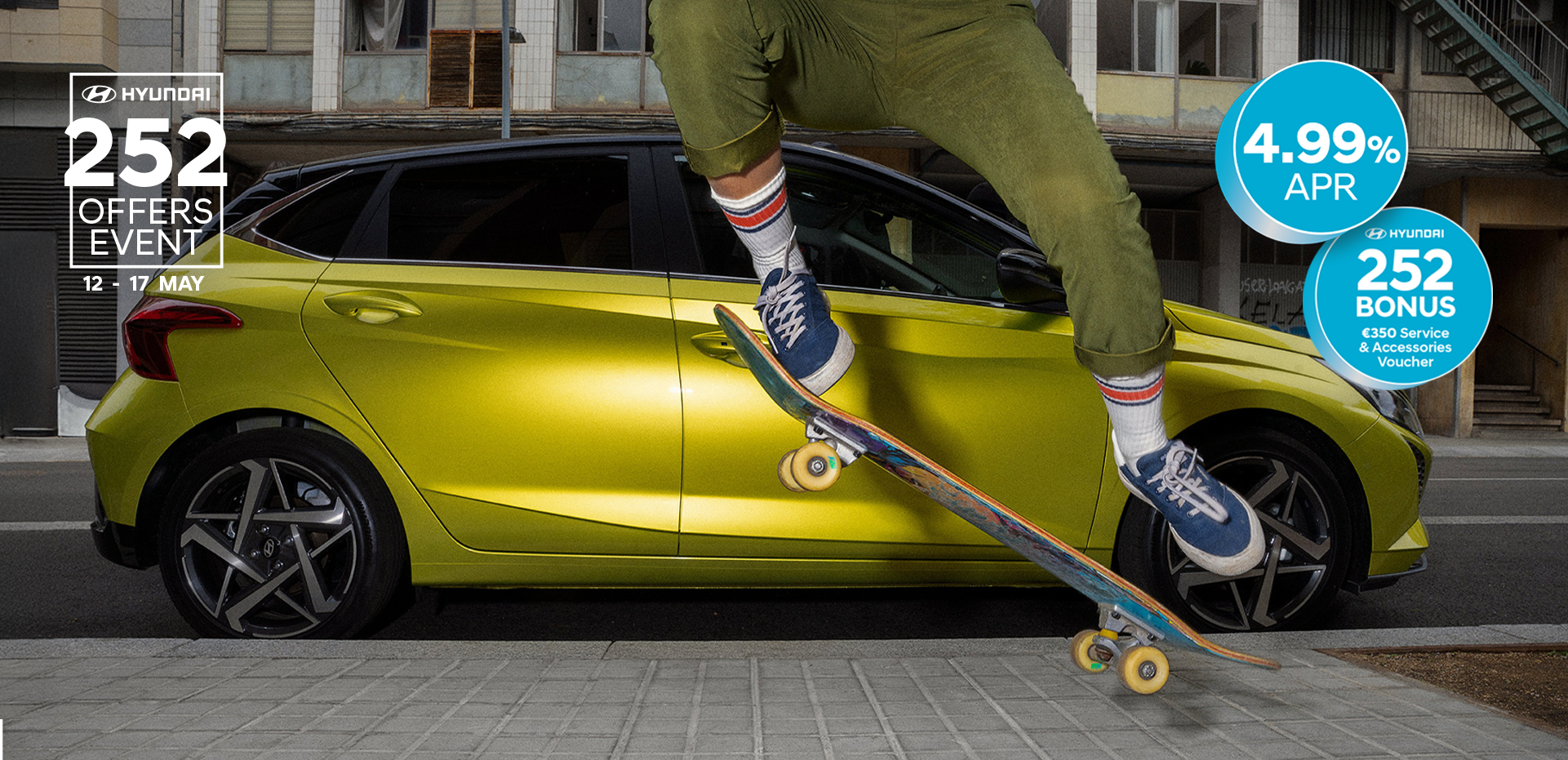 A young woman skateboarding in the street with a Hyundai i20 in the background.	