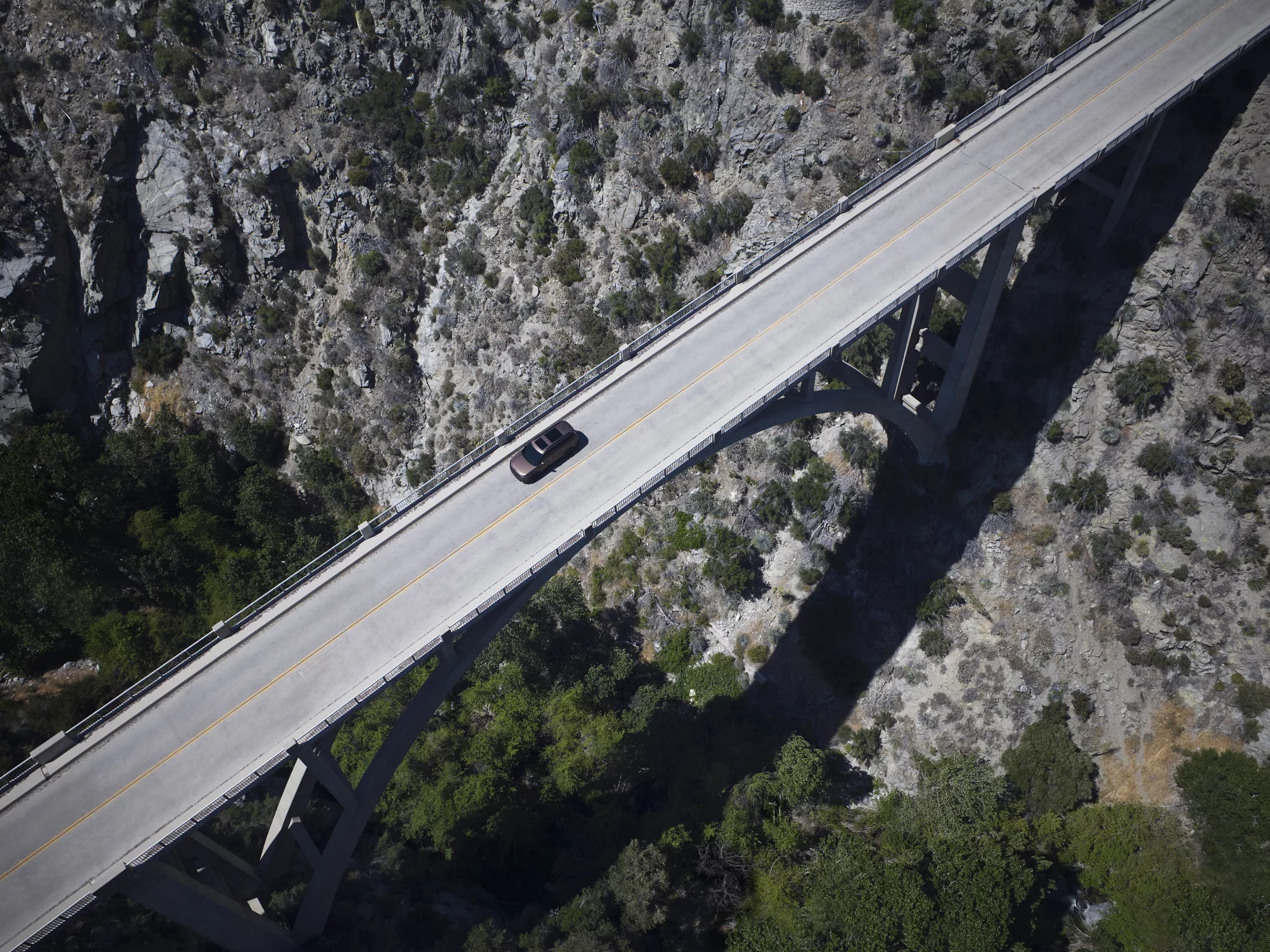 Hyundai Santa Fe driving on long bridge.