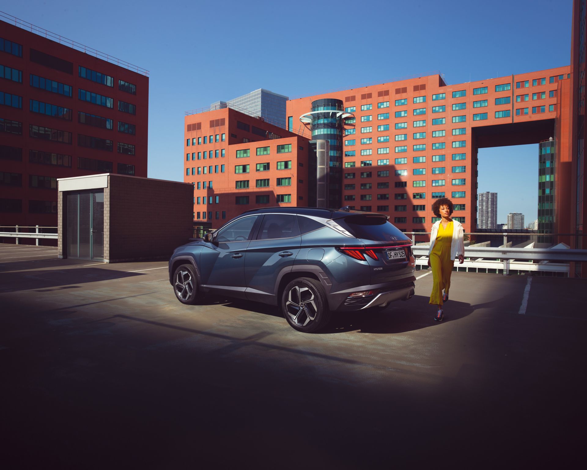 The Tucson compact SUV pictured from the rear parked near a waterfront skyline.